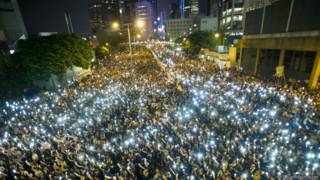 Manifestantes alzan sus teléfonos celulares durante una protesta en Hong Kong el 29-09-2014.