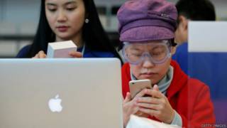 北京某蘋果專賣店內一名女顧客在試用iPhone 6(17/10/2014)