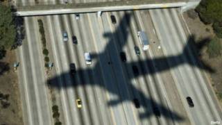 La sombra de un avión sobre una calle citadina