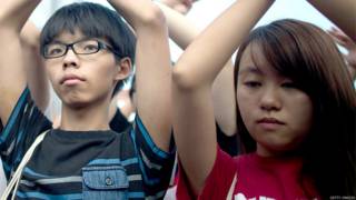 黃之鋒(左)與錢詩文(右)在金紫荊廣場外舉起抗議手勢(1/10/2014)