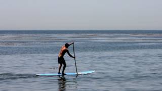 A man paddle surfing in California