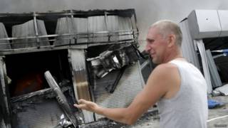 Мужчина возле разрушенного магазина в Донецке