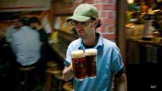 Un barman sirve tarros de cerveza en México