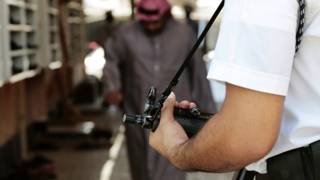 شرطي سعودي يحمل بندقية