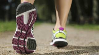 Los pies de un corredor sobre el asfalto