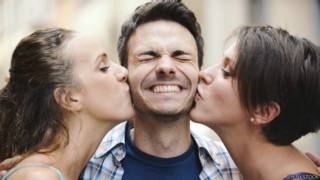 Unas chicas besan a un joven
