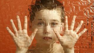 Un niño detrás de un cristal