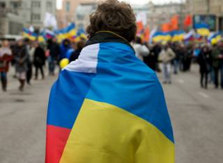 Мужчина, одетый в флаги России и Украины