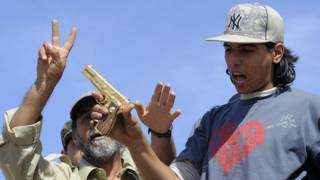 Mohammed Elbibi con la pistola de oro de Gadafi