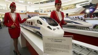 身穿雅玩高鐵乘務員制服的女士展示高鐵列車模型(資料圖片)