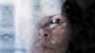 El rostro de una mujer tras una especie de cortina de humo