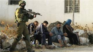 جندي إسرائيلي يصوب بندقيته تجاه فلسطينيين من يطا