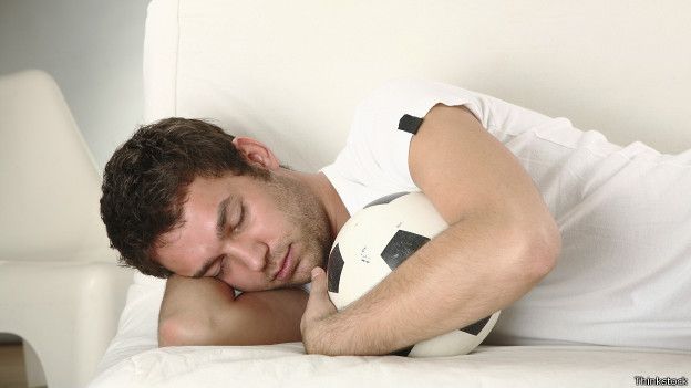 Una persona dormida con una pelota de fútbol