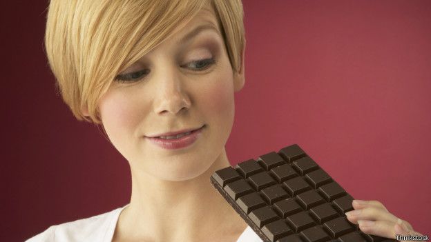 Mujer comiendo una barra de chocolate