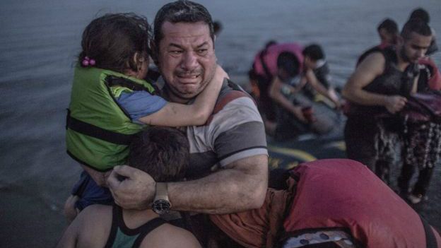 Un inmigrantes llora y abraza a sus hijos tras lograr llegar a las costas de Grecia
