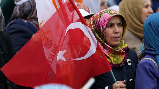 Una mujer sostiene una bandera turca