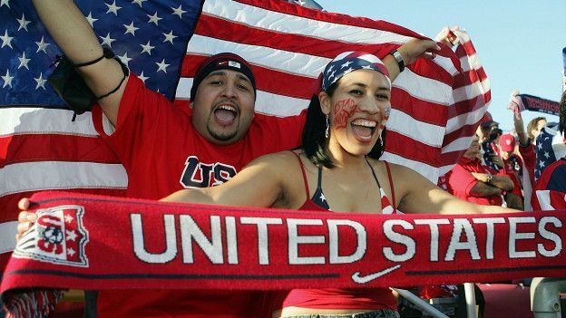 Dos personas sostienen la bandera de Estados Unidos