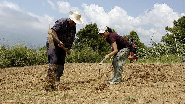 Una miembro de los Cuerpos de Paz de El Salvador con un campesino