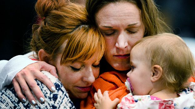 Renee Wetzel y su niña junto a una mujer que intenta consolarla. Wetzel perdió a su esposo Michael, una de las víctimas del tiroteo de San Bernardino.ju