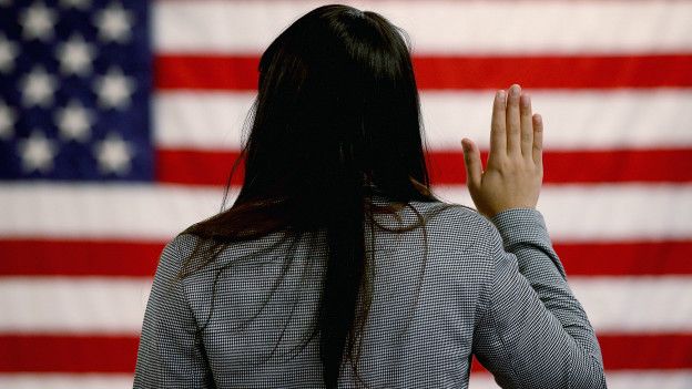Mujer de espaldas jurando la bandera estadounidense