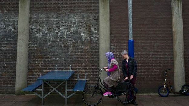 Aquí, un voluntario holandés enseña a una refugiada afgana a montar bicicleta.