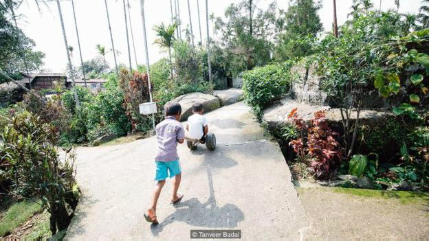 Image caption Anak-anak bermain di jalanan desa Mawlynnong (Credit: Tanveer Badal)
