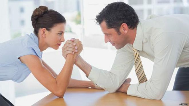 Dos personas haciendo una pulseada en el trabajo