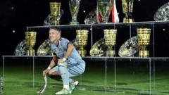 Bastian Schweinsteiger poses with all the trophies he won while at Bayern Munich