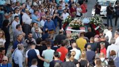 Relatives and friends march behind a hearse carrying Reyes