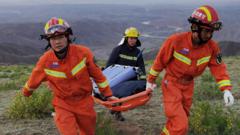 Αυτή η φωτογραφία που τραβήχτηκε στις 22 Μαΐου 2021 δείχνει διασώστες να κουβαλούν εξοπλισμό καθώς αναζητούν δρομείς που συμμετείχαν σε αγώνα δρόμου cross-country 100 χιλιομέτρων όταν ακραία καιρικά φαινόμενα έπληξαν την περιοχή, αφήνοντας τουλάχιστον 20 νεκρούς, κοντά στην πόλη Baiyin στην Κίνα. βορειοδυτική επαρχία Gansu