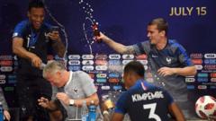 France manager Didier Deschamps has his press conference interrupted by his jubilant players following their 4-2 victory over Croatia.