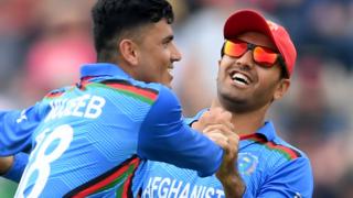 Afghanistan's Mujeeb celebrates taking a wicket