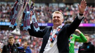 Dean Smith salutes the Aston Villa fans with the Championship play-off final trophy
