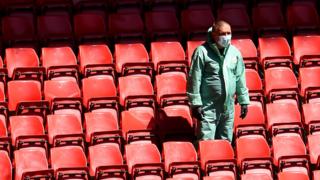 A Liverpool staff member at Anfield in full PPE