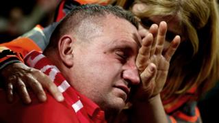 A tearful fan is consoled