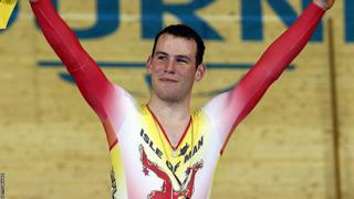 Mark Cavendish stands with his arms aloft on the podium at the 2006 Commonwealth Games