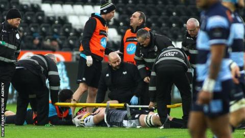 Adam Beard in a stretcher