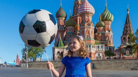 A child holds a football balloon