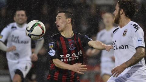 Crusaders winger Paul Heatley shields the ball from Glentoran's Fra McCaffrey