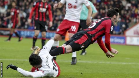 adam smith (right) falls under the tackle of sofiane boufal