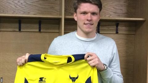 Rob Dickie holds up an Oxford United shirt