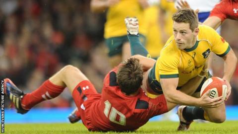 Bernard Foley in tackled by Dan Biggar