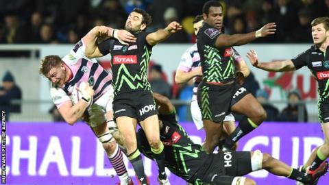 Macauley Cook of Cardiff Blues is tackled by Julien Tomas and Masalosalo Tutaia of Pau