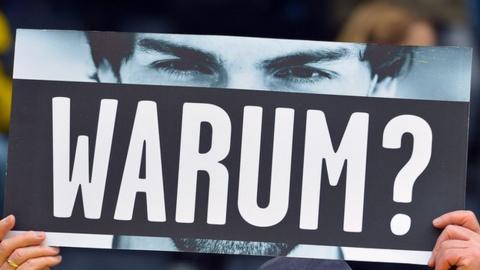 A fan holds up a banner asking Mats Hummels 'why?' at a recent Borussia Dortmund game