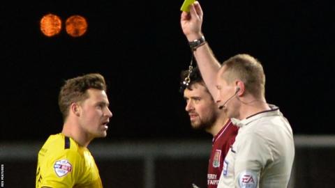 Oxford United striker Chris Maguire booked by referee Keith Hill