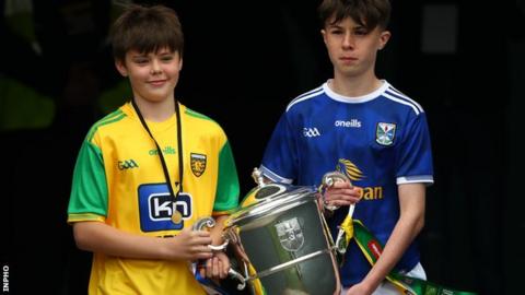 Two young Donegal and Cavan fans carry the Anglo Celt Cup out at Clones ahead of the 2019 Ulster SFC final