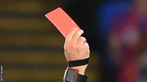 A referee showing a red card