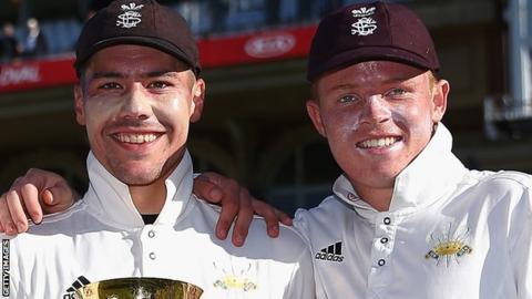 Rory Burns and Ollie Pope celebrate with the County Championship trophy in 2018