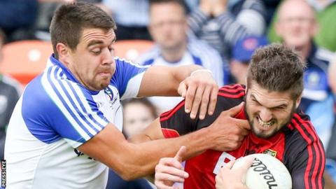 Drew Wylie of Monaghan challenges Down forward Connaire Harrison in the Ulster semi-final on 24 June