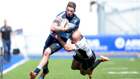 Alex Cuthbert of Cardiff Blues is tackled by Brendon Leonard of Zebre